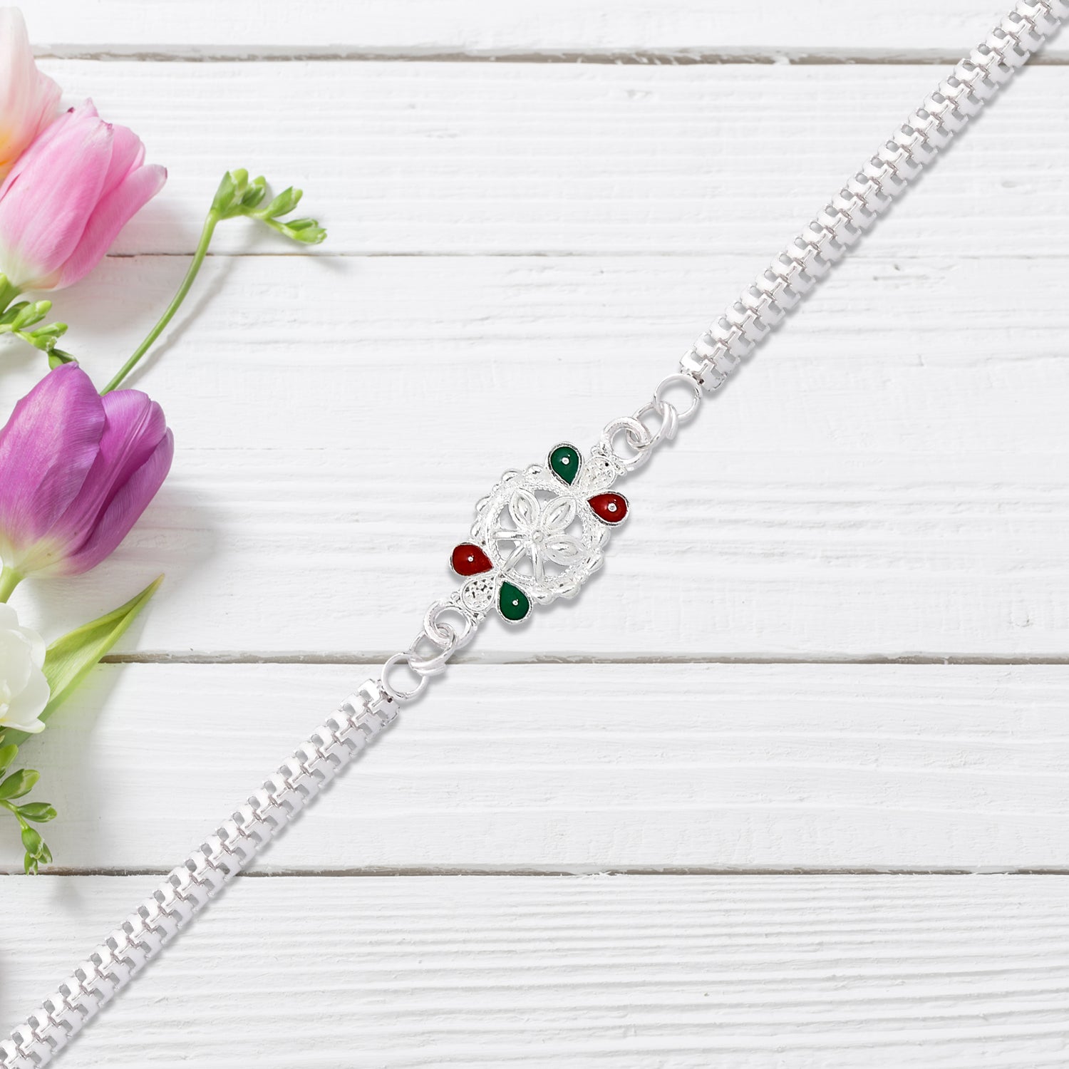 Delicate Metal Chain Rakhi With Enamel Floral Center Delicate Metal Chain Rakhi With Enamel Floral Center